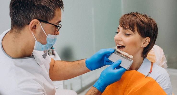 Dentist reassuring an adult patient before veneer treatment during a cosmetic dental consultation.
