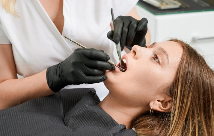 Dentist reviewing digital dental X-rays with an adult patient before recommending tooth extraction.